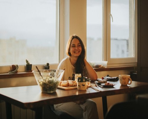 Persona desayunando tranquila en casa antes de trabajar